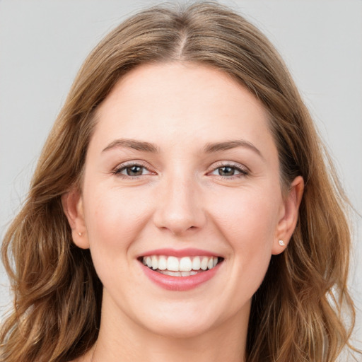 Joyful white young-adult female with long  brown hair and grey eyes