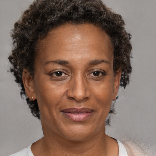 Joyful black adult female with short  brown hair and brown eyes