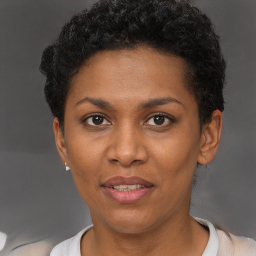 Joyful black young-adult female with short  brown hair and brown eyes