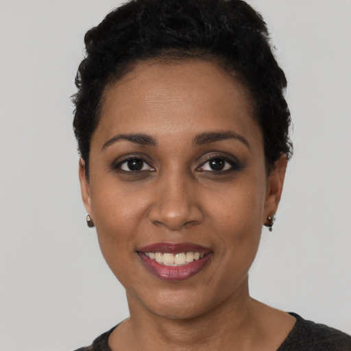 Joyful latino young-adult female with short  black hair and brown eyes