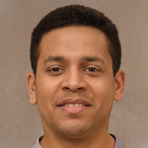 Joyful latino young-adult male with short  brown hair and brown eyes