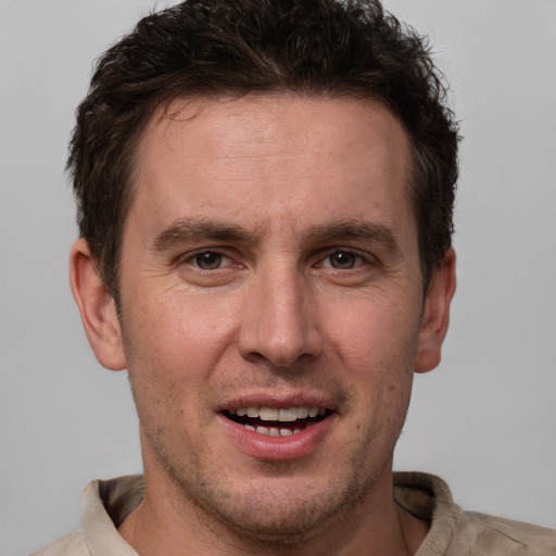 Joyful white adult male with short  brown hair and grey eyes