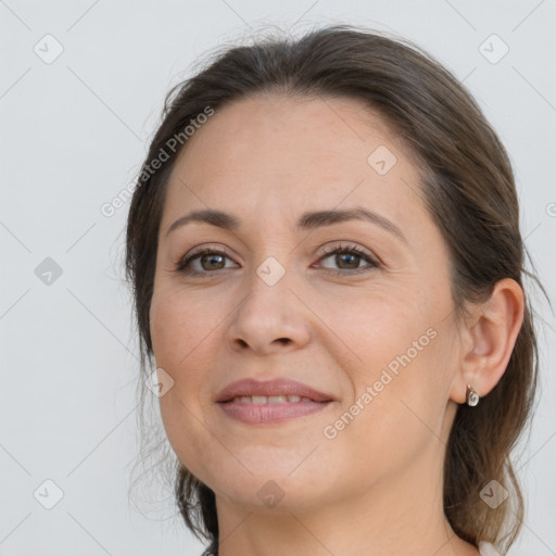 Joyful white adult female with long  brown hair and brown eyes