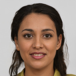 Joyful latino young-adult female with long  brown hair and brown eyes