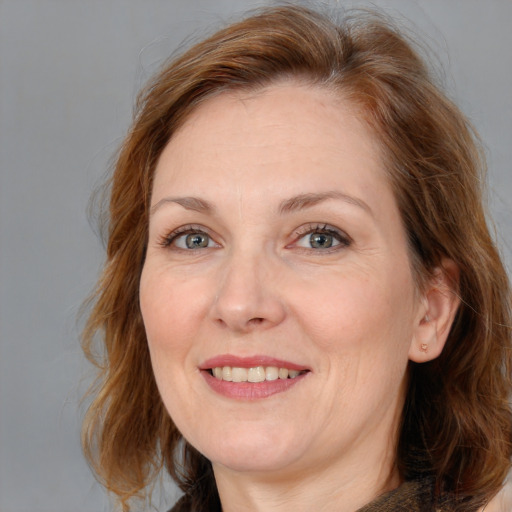 Joyful white adult female with medium  brown hair and blue eyes