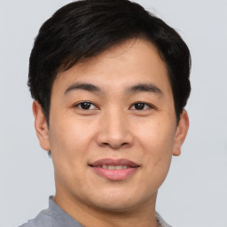 Joyful asian young-adult male with short  brown hair and brown eyes