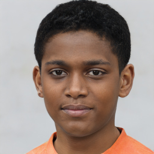 Joyful black child male with short  brown hair and brown eyes
