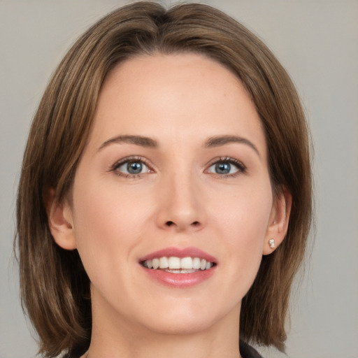 Joyful white young-adult female with medium  brown hair and grey eyes