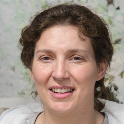 Joyful white adult female with medium  brown hair and blue eyes