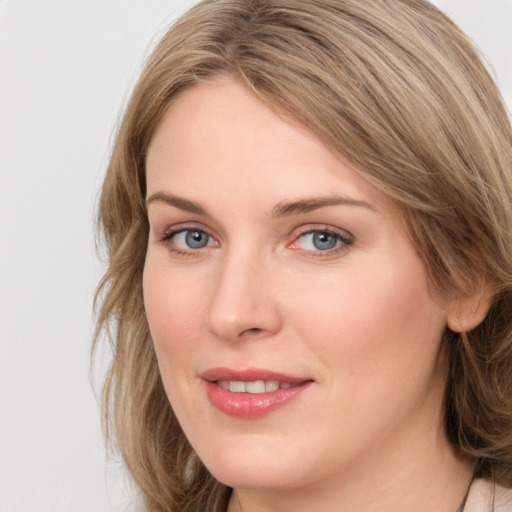 Joyful white young-adult female with long  brown hair and blue eyes