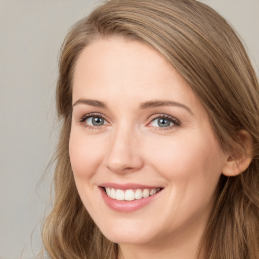 Joyful white young-adult female with long  brown hair and grey eyes