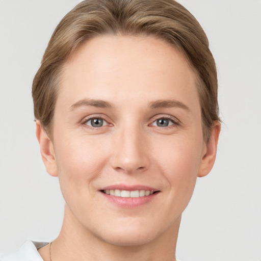 Joyful white young-adult female with short  brown hair and grey eyes