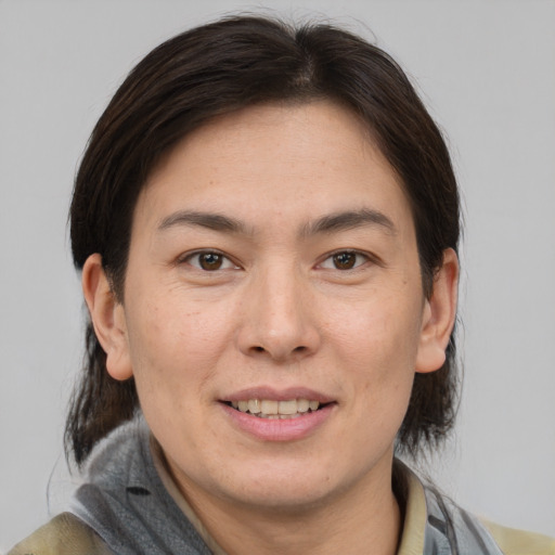 Joyful asian adult female with medium  brown hair and brown eyes