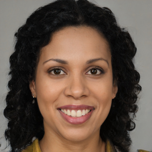 Joyful black young-adult female with long  brown hair and brown eyes