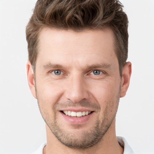 Joyful white young-adult male with short  brown hair and grey eyes