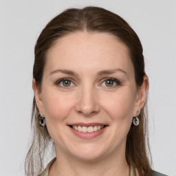 Joyful white young-adult female with long  brown hair and grey eyes