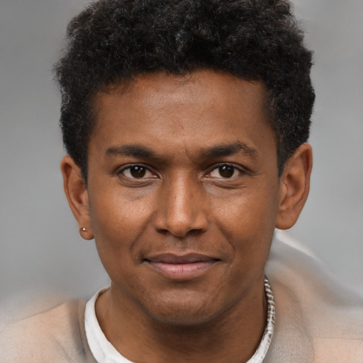 Joyful black young-adult male with short  brown hair and brown eyes