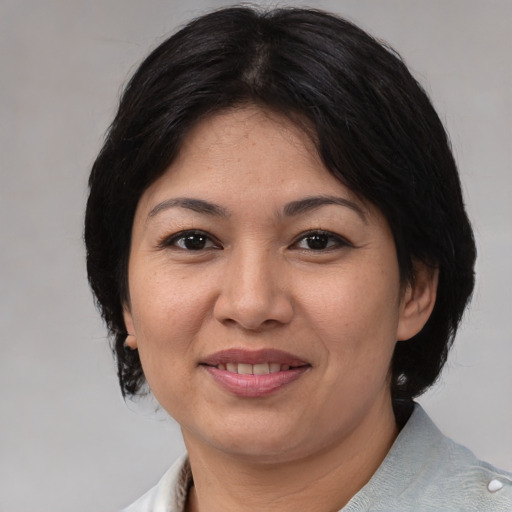 Joyful asian adult female with medium  brown hair and brown eyes