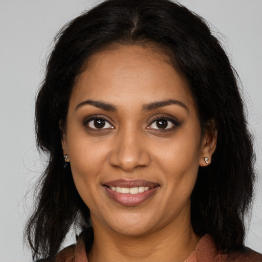Joyful black young-adult female with long  brown hair and brown eyes