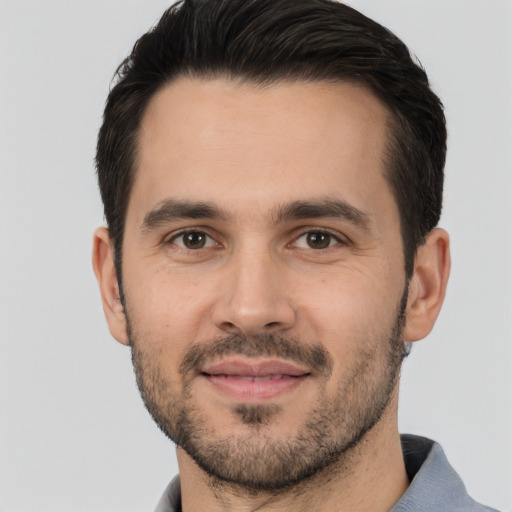 Joyful white young-adult male with short  black hair and brown eyes