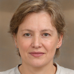 Joyful white adult female with medium  brown hair and grey eyes