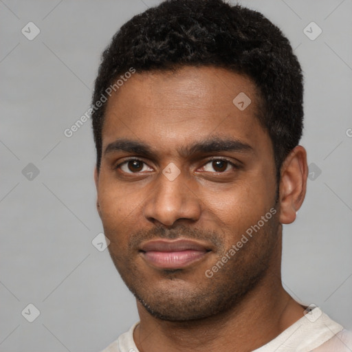 Joyful black young-adult male with short  black hair and brown eyes