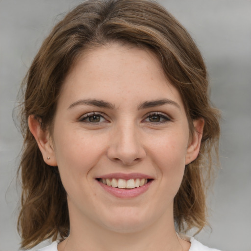 Joyful white young-adult female with medium  brown hair and grey eyes