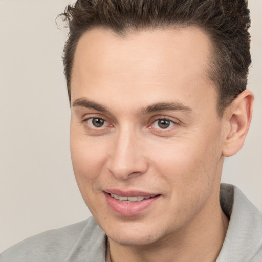 Joyful white young-adult male with short  brown hair and brown eyes