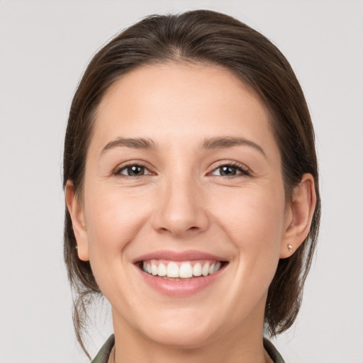 Joyful white young-adult female with medium  brown hair and grey eyes