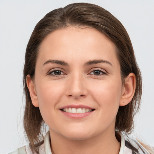 Joyful white young-adult female with medium  brown hair and grey eyes