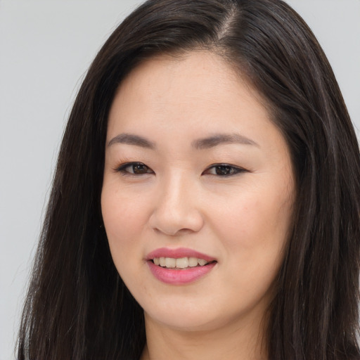 Joyful asian young-adult female with long  brown hair and brown eyes