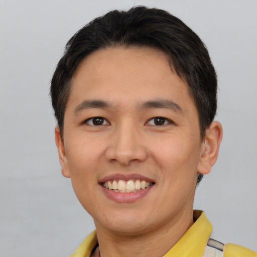 Joyful asian young-adult male with short  brown hair and brown eyes