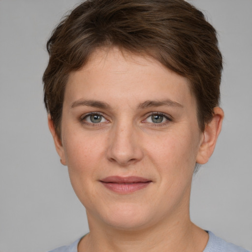 Joyful white young-adult female with short  brown hair and grey eyes