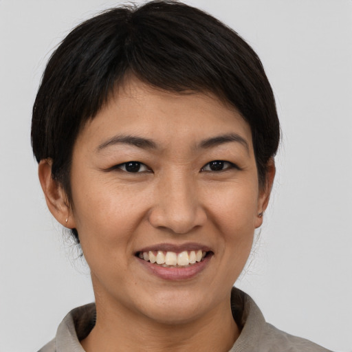 Joyful asian young-adult female with short  brown hair and brown eyes
