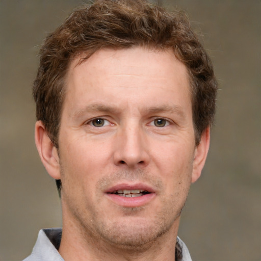 Joyful white adult male with short  brown hair and grey eyes