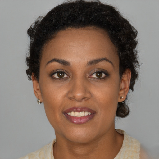 Joyful black young-adult female with short  brown hair and brown eyes