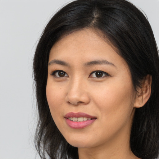 Joyful asian young-adult female with long  brown hair and brown eyes