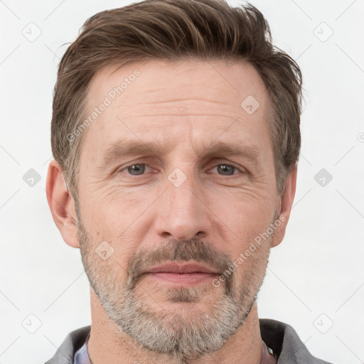 Joyful white adult male with short  brown hair and grey eyes