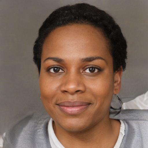Joyful black young-adult female with short  black hair and brown eyes