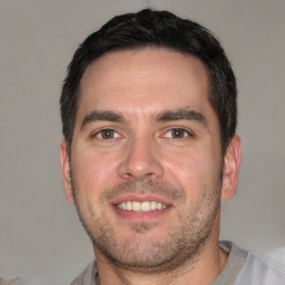 Joyful white young-adult male with short  black hair and brown eyes