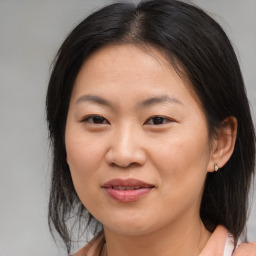 Joyful asian young-adult female with medium  brown hair and brown eyes