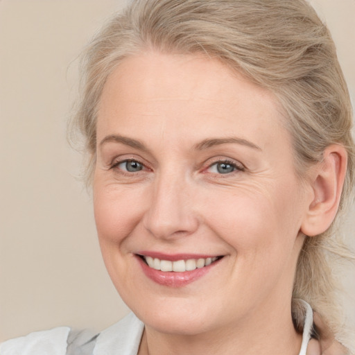 Joyful white adult female with medium  brown hair and blue eyes