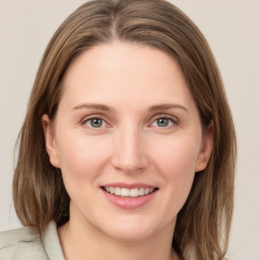 Joyful white young-adult female with medium  brown hair and grey eyes