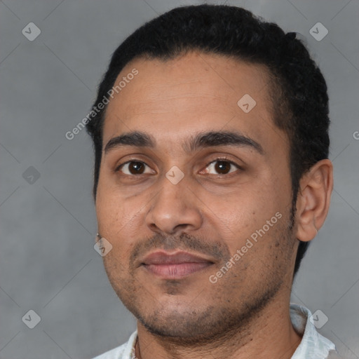 Joyful latino young-adult male with short  black hair and brown eyes