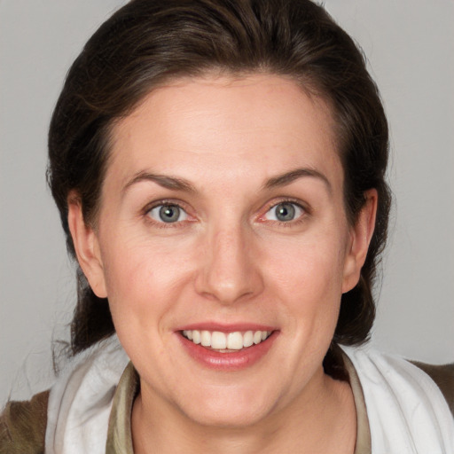 Joyful white adult female with medium  brown hair and grey eyes