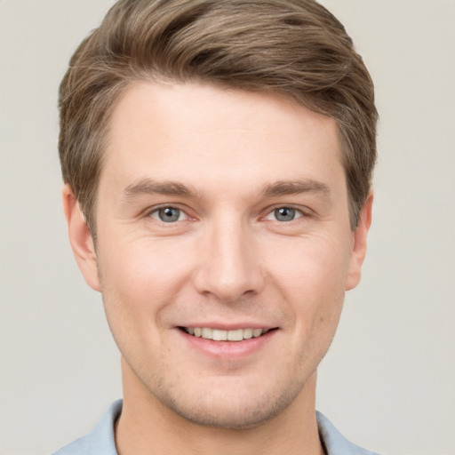 Joyful white young-adult male with short  brown hair and grey eyes