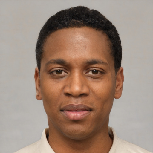 Joyful black young-adult male with short  black hair and brown eyes