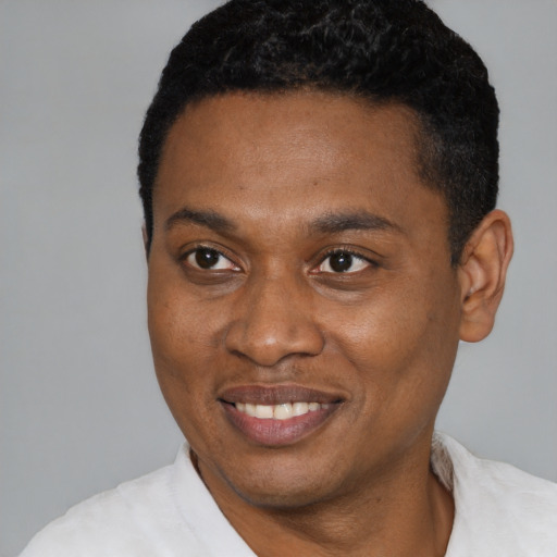 Joyful black young-adult male with short  black hair and brown eyes