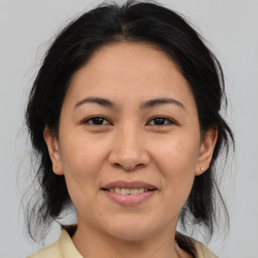 Joyful asian adult female with medium  brown hair and brown eyes