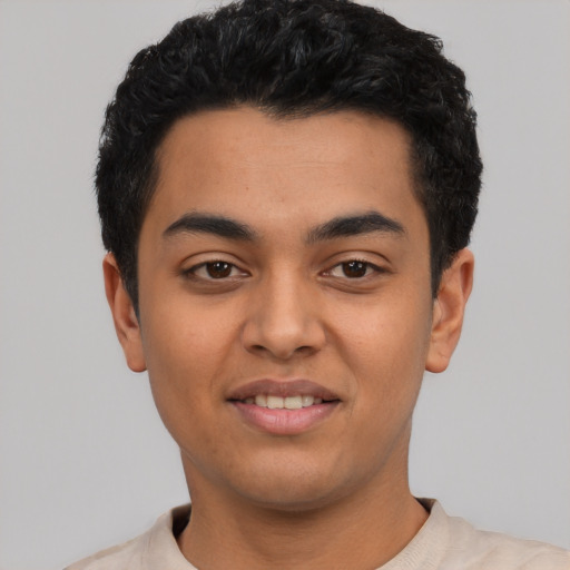 Joyful latino young-adult male with short  black hair and brown eyes